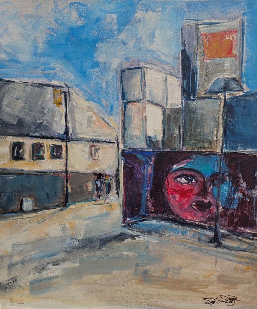 Scène urbaine avec une grande murale représentant un visage.